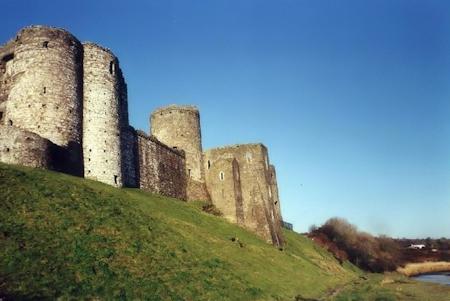 Kidwelly Castle walls and steep bank down to the river